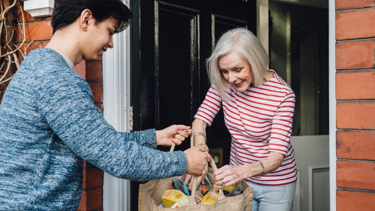 Boy delivering groceries to a woman