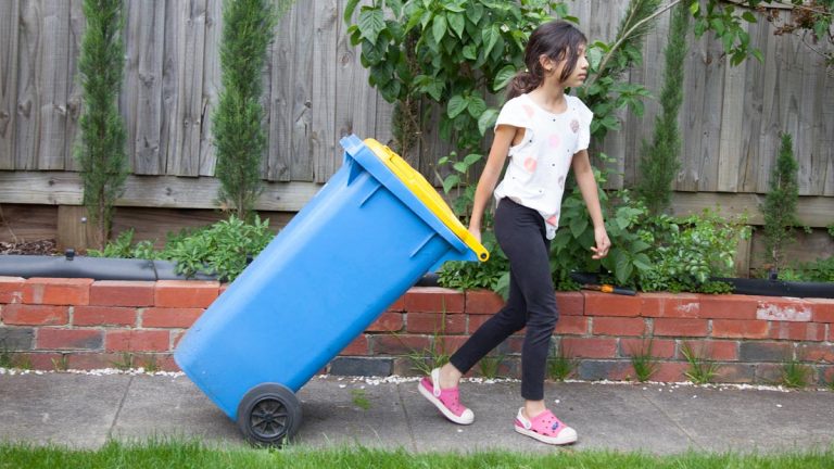 Girl pulling a trash can