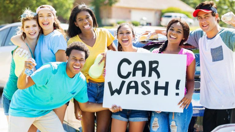 Teens with sign for car wash