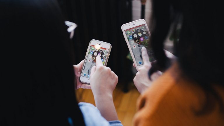 two ladies on mobile phones selecting apps